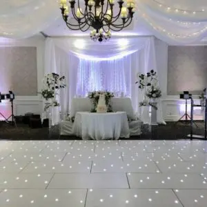 A white dance floor with lights and a chandelier