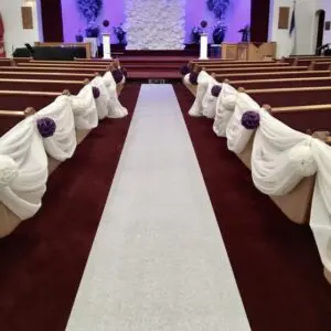 A church with purple flowers and white carpet