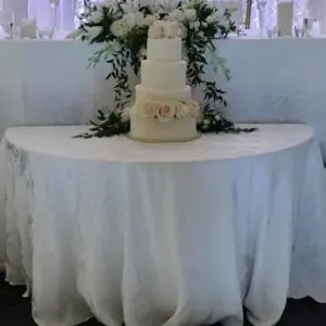 A table with a white cloth and three tiers of cake