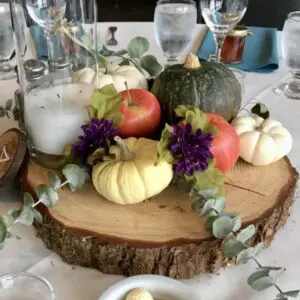 A table with a wooden slab and some pumpkins