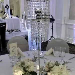 A table with white flowers and a crystal chandelier.