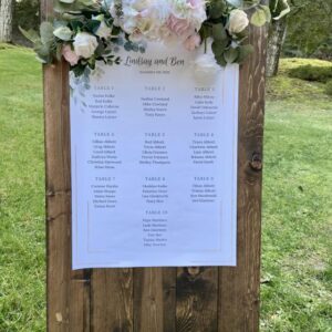 A wooden sign with a bunch of flowers on it