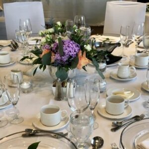 A table set with white plates and silverware.