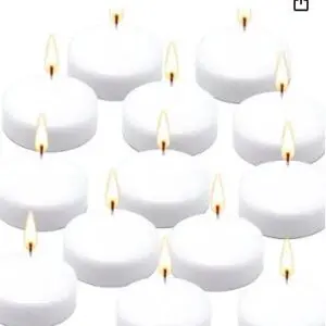 A group of white candles that are sitting on the floor.