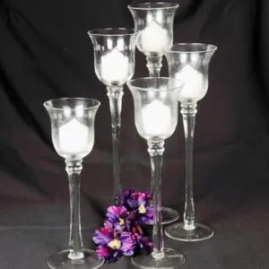 A group of five clear glass candle holders.