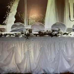 A table with white cloth and flowers on it