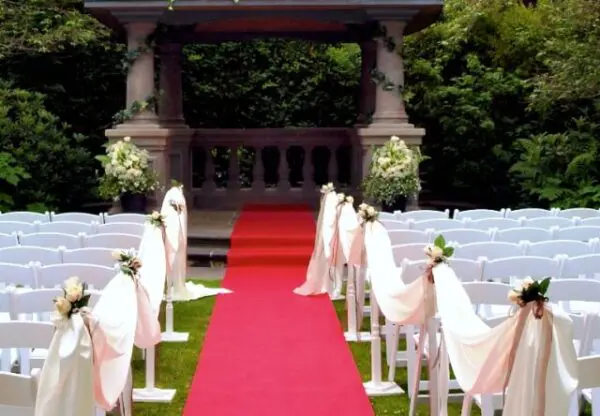 A red carpet is set up for an outdoor wedding.