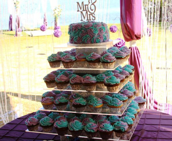 A wedding cake with cupcakes on top of it.