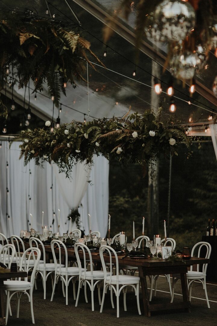 A wedding reception with white chairs and lights