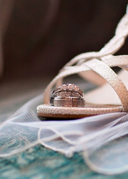 A pair of wedding rings sitting on top of a sandal.