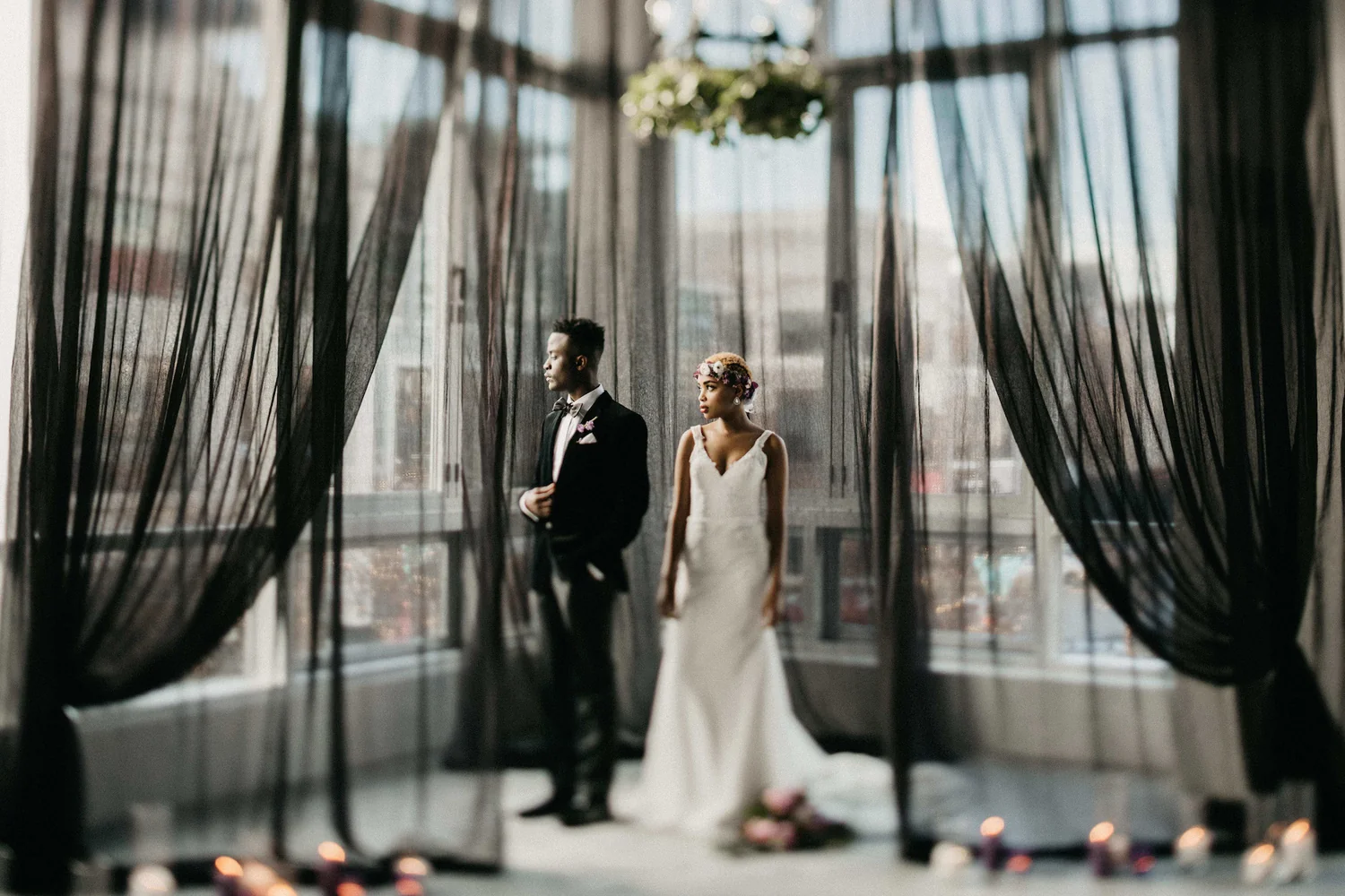 A man and woman standing in front of a window.