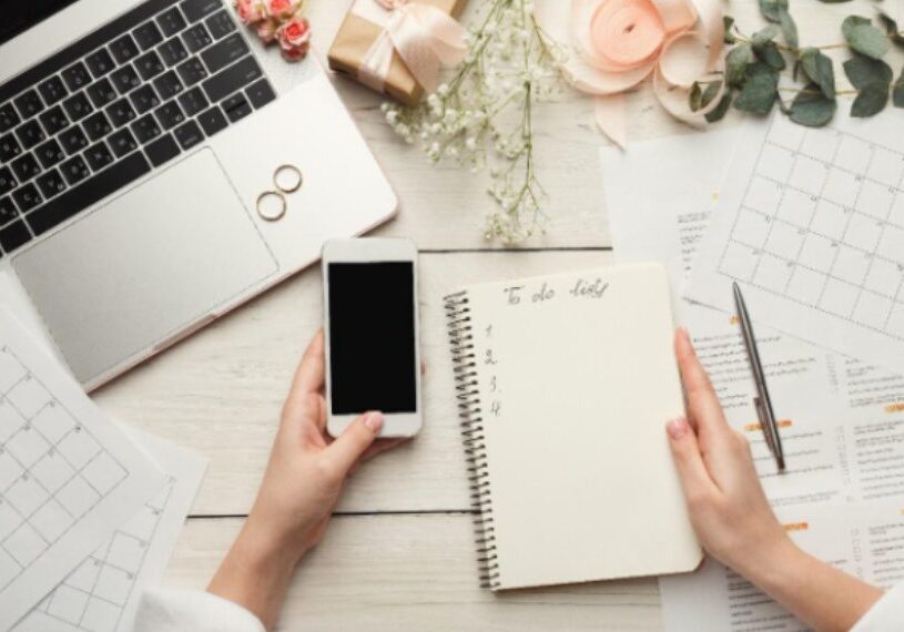 A person holding a phone and a notebook