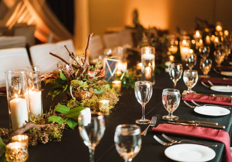 A table set with wine glasses and candles.