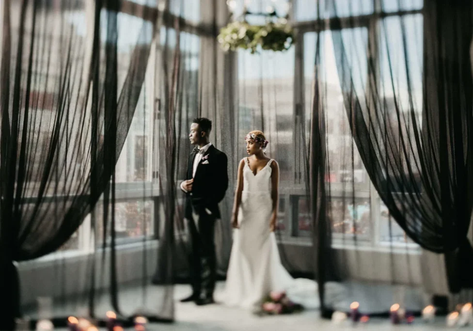 A man and woman standing in front of a window.